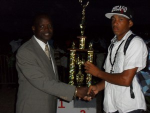 Minister Nimrod presents winning trophy to HSS athlete Uriah Enoe