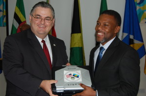 U.S. Chargé d’Affaires Louis Crishock handing over a Toughbook to CDEMA’s Executive Director Ronald Jackson