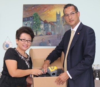 Health Minister Nickolas Steele receives items from Madam Ou Boqian, resident Chinese Ambassador to Grenada.
