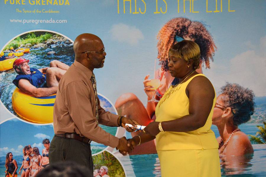 4Sep2015---Mr.-Lincoln-Morgan,-CEO-of-the-GNTA-hands-a-certificate-to-a-Grand-Anse-beach-salesperson