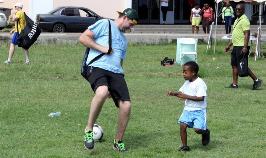 JRF Team Member and child playing soccer