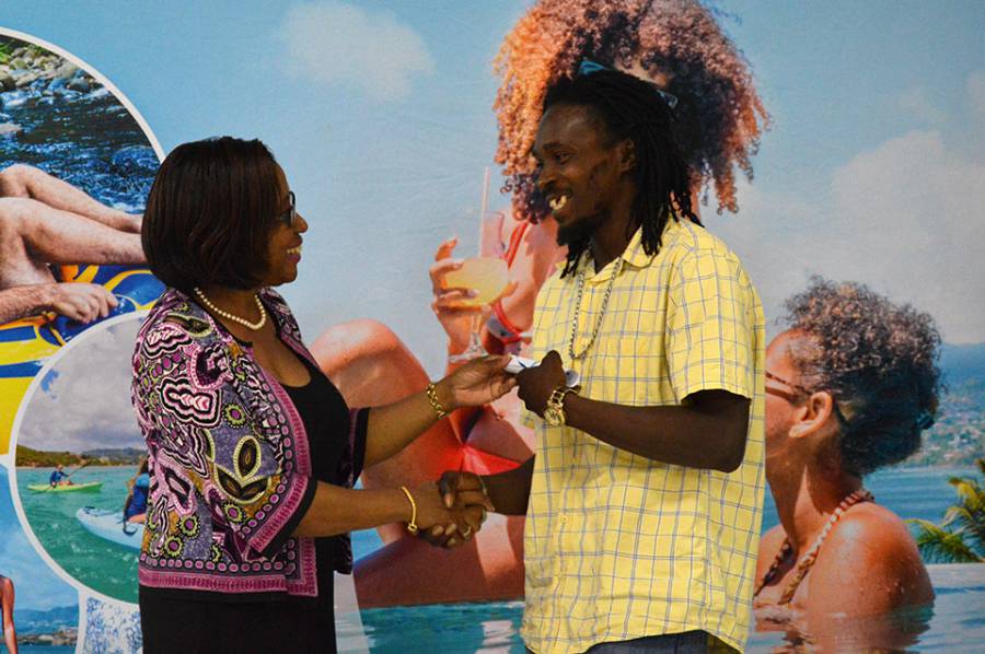 Mrs.-Arlene-Buckmire-Outram,-PS-of-Ministry-of-Tourism-hands-a-certificate-to-a-Grand-Anse-beach-salesperson